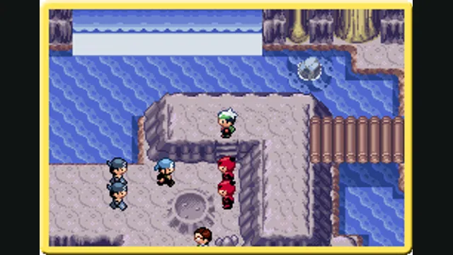A trainer stands near opposing teams beside a rocky inlet in the original Pokémon Emerald.