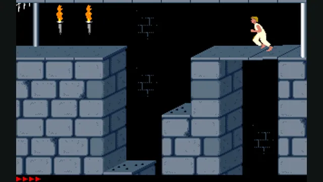 The prince crouches on a stone platform above a pit in the DOS Prince of Persia. Original-game reference.